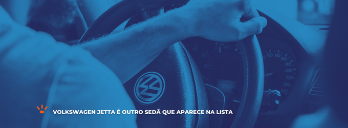 Homem dirigindo com a mão no volante e com a logo da marca Volkswagen