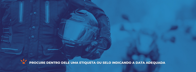 Homem segurando um capacete de moto