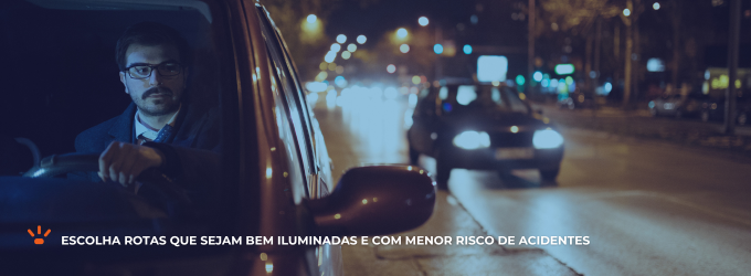 Homem dirigindo um carro em uma rua iluminada.