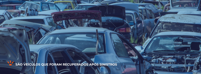 Carros danificados em um pátio.